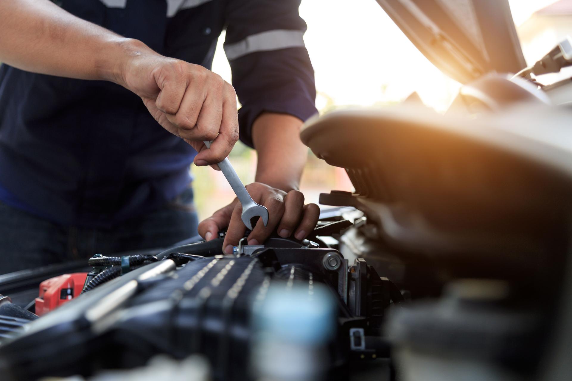 Automobile mechanic repairman hands repairing a car engine automotive workshop with a wrench, car service and maintenance,Repair service.