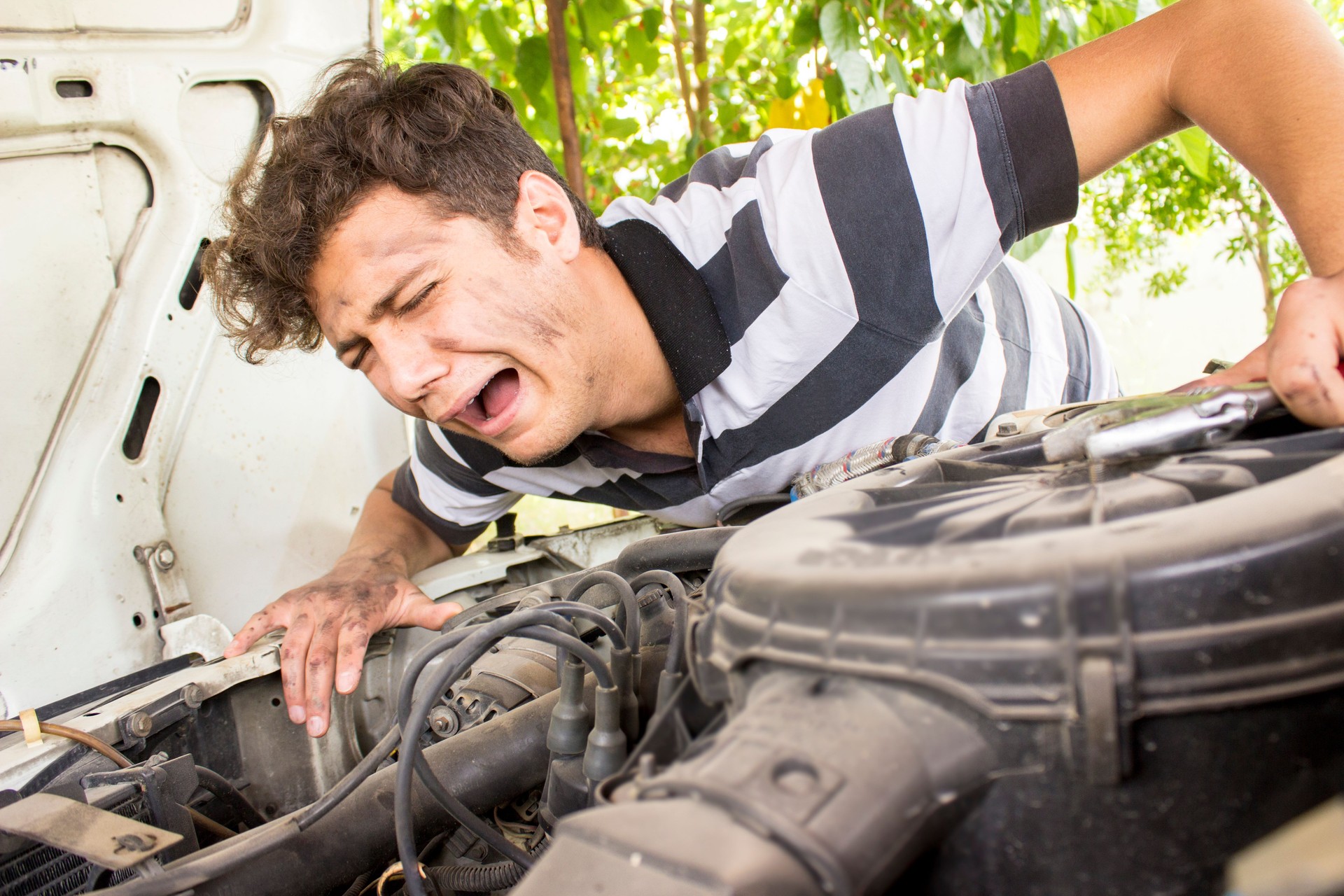 Incompetent repairman crying next to car